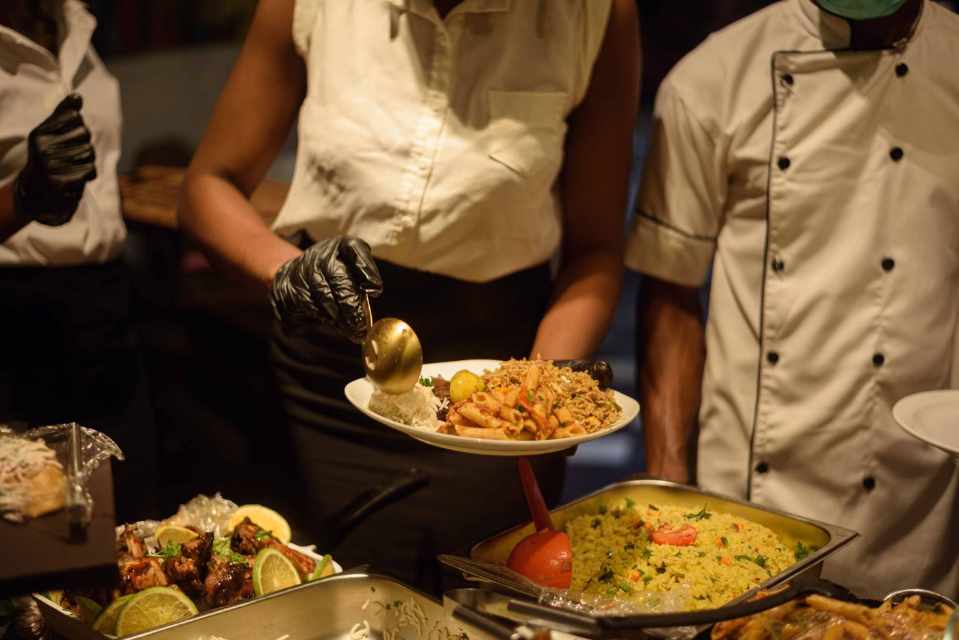 Catering staff serving food from a buffet